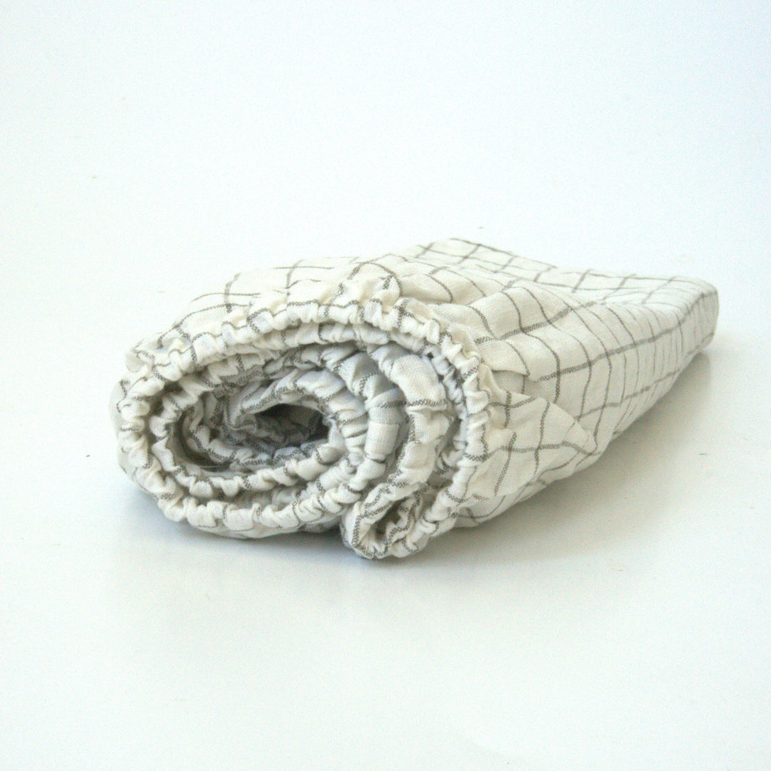 Foxtrot Home French Flax Linen styled in a baby's bedroom with Cactus Grid Cot Sheet and Bassinet Sheets.