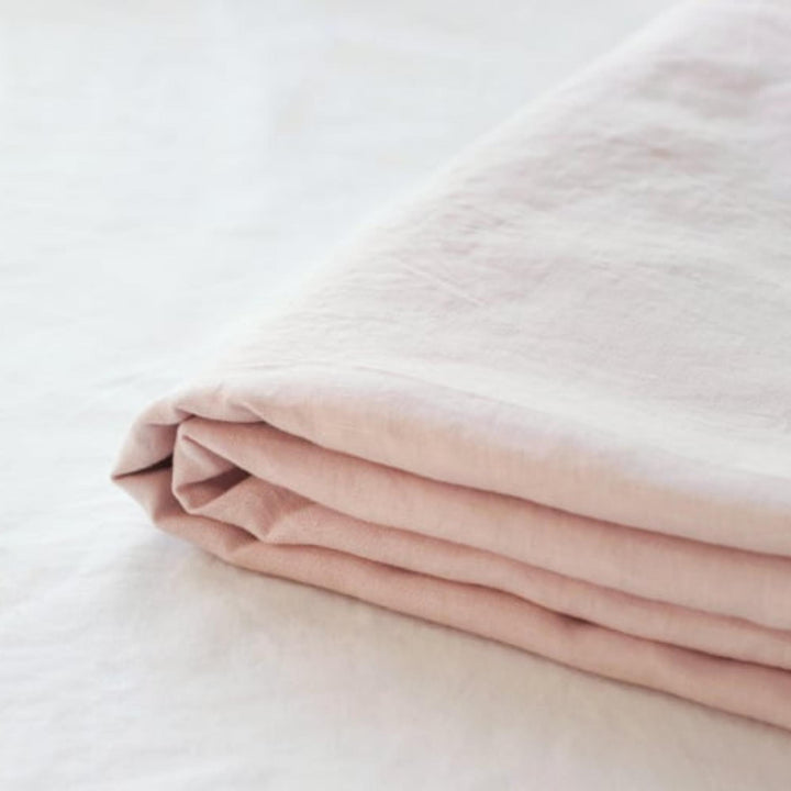 Foxtrot Home French Flax Linen styled in a baby's bedroom with Blush Pink Cot Sheet and Bassinet Sheets.