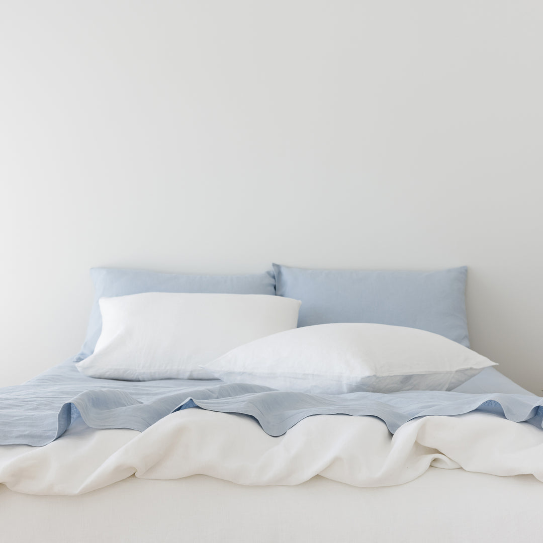 Foxtrot Home French Flax Linen styled in a bedroom with Brilliant White Duvet, Powder Blue Sheets Set and Pillowcases.