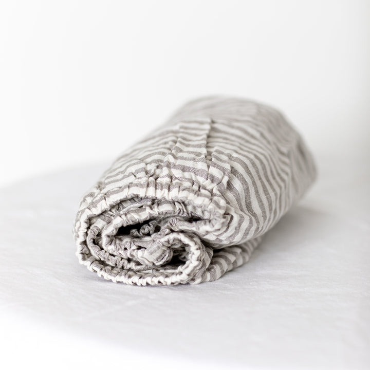 Foxtrot Home French Flax Linen styled in a baby's bedroom with Grey Stripes Cot Sheet and Bassinet Sheets.