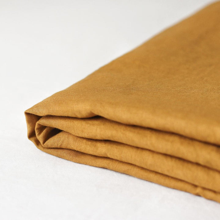 Foxtrot Home French Flax Linen styled in a baby's bedroom with Honey Ginger Cot Sheet and Bassinet Sheets.