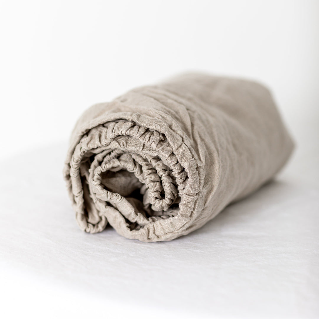 Foxtrot Home French Flax Linen styled in a baby's bedroom with Natural Cot Sheet and Bassinet Sheets.
