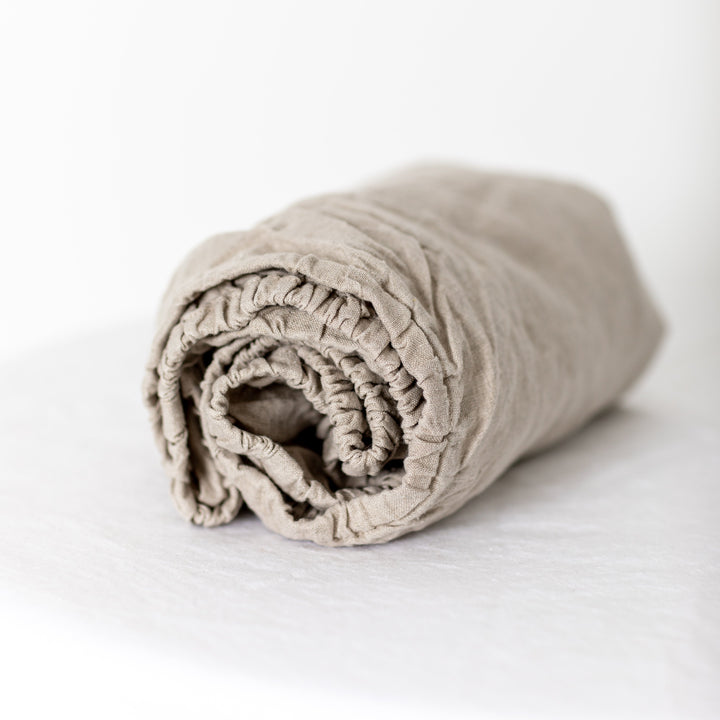 Foxtrot Home French Flax Linen styled in a baby's bedroom with Natural Cot Sheet and Bassinet Sheets.