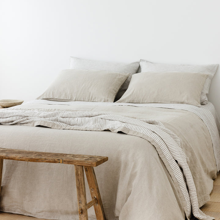 Foxtrot Home French Flax Linen styled in a bedroom with Natural Duvet, Grey Stripes Sheets Set and Pillowcases.