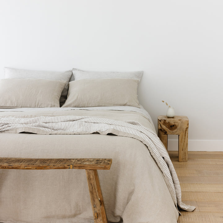 Foxtrot Home French Flax Linen styled in a bedroom with Natural Duvet, Grey Stripes Sheets Set and Pillowcases.