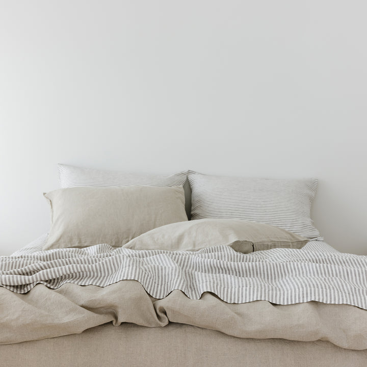 Foxtrot Home French Flax Linen styled in a bedroom with Natural Duvet, Grey Stripes Sheets Set and Pillowcases.