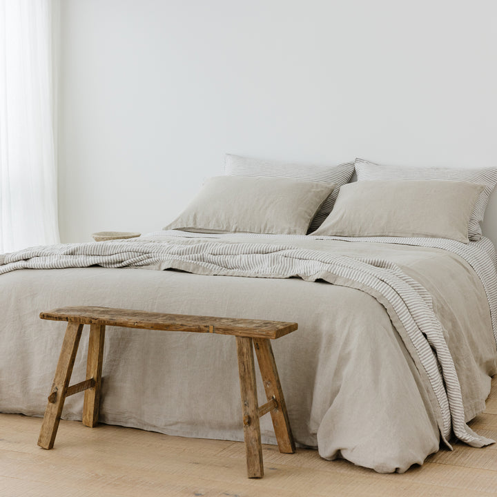 Foxtrot Home French Flax Linen styled in a bedroom with Natural Duvet, Grey Stripes Sheets Set and Pillowcases.
