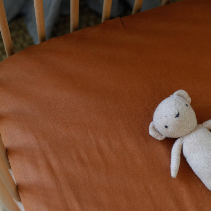 Foxtrot Home French Flax Linen styled in a baby's bedroom with Tobacco Cot Sheet and Bassinet Sheets.