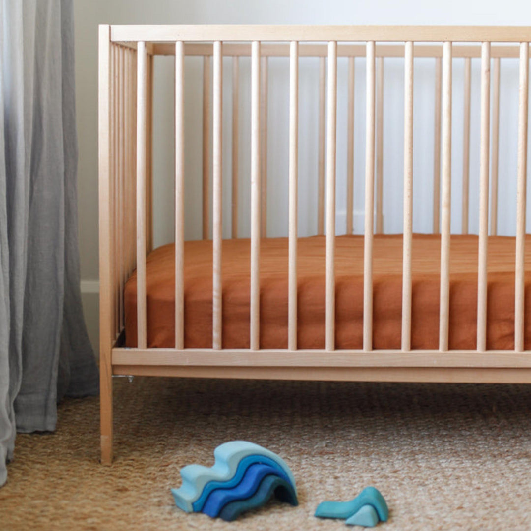 Foxtrot Home French Flax Linen styled in a baby's bedroom with Tobacco Cot Sheet and Bassinet Sheets.