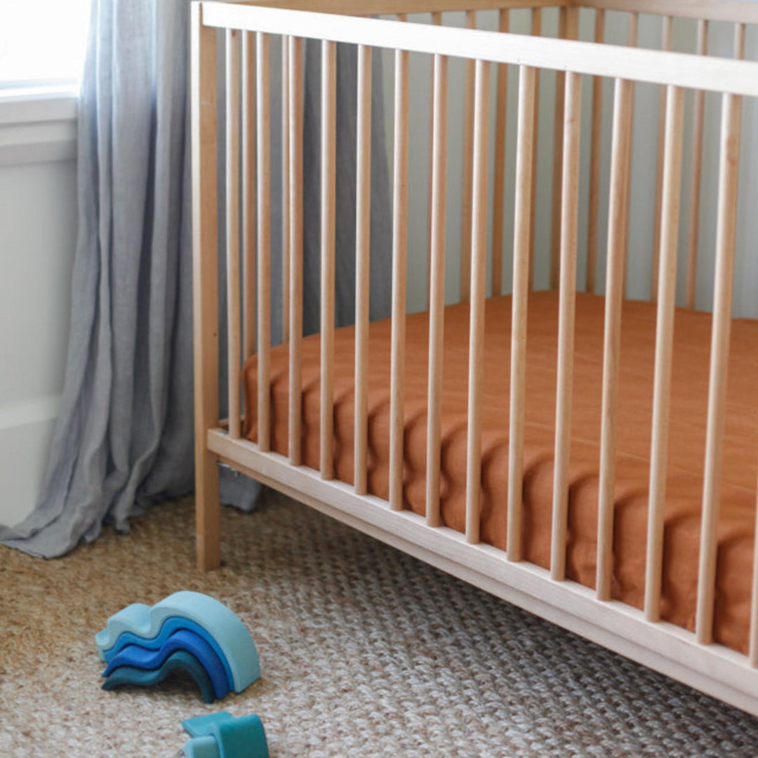 Foxtrot Home French Flax Linen styled in a baby's bedroom with Tobacco Cot Sheet and Bassinet Sheets.