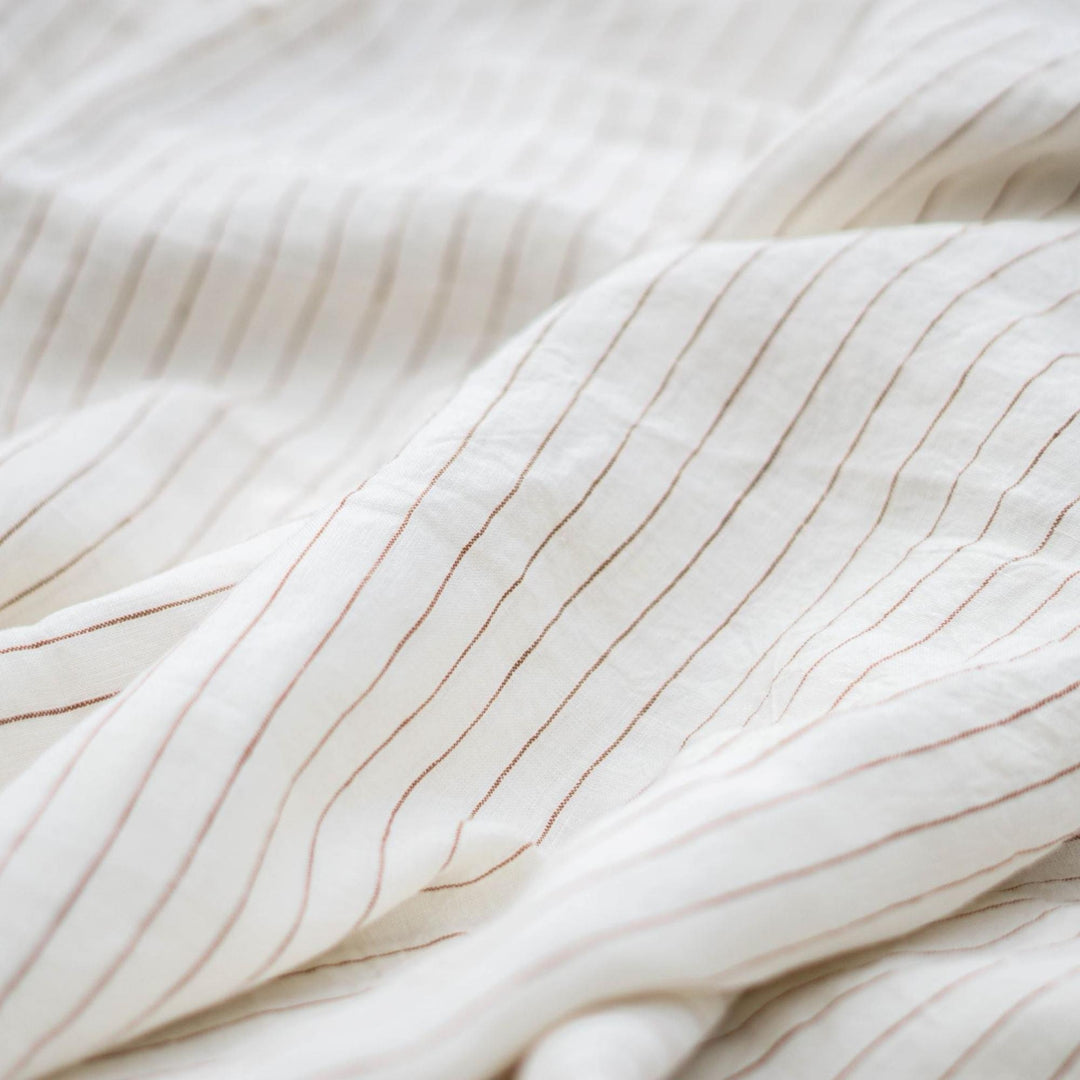 Foxtrot Home French Flax Linen styled in a baby's bedroom with a Tobacco Stripes Cot Duvet.