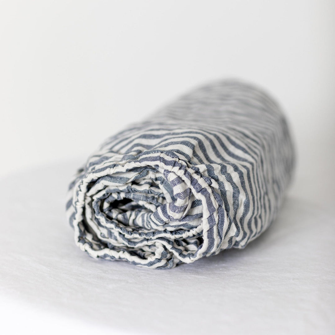 Foxtrot Home French Flax Linen styled in a baby's bedroom with Navy Stripes Cot Sheet and Bassinet Sheets.