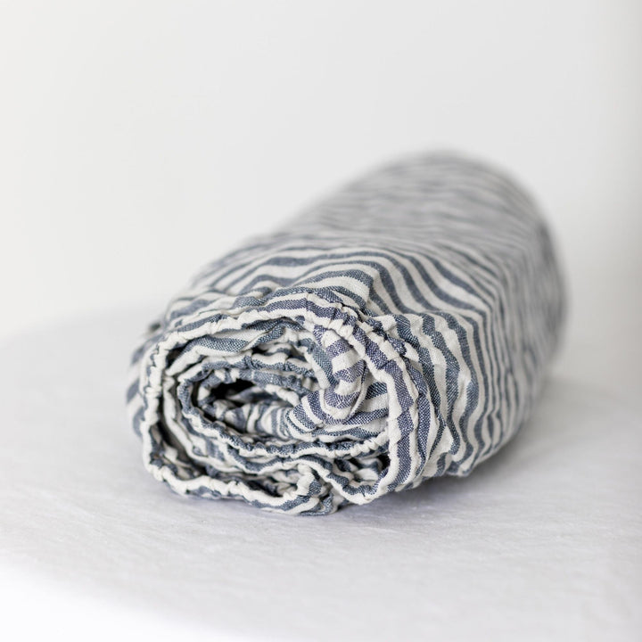 Foxtrot Home French Flax Linen styled in a baby's bedroom with Navy Stripes Cot Sheet and Bassinet Sheets.