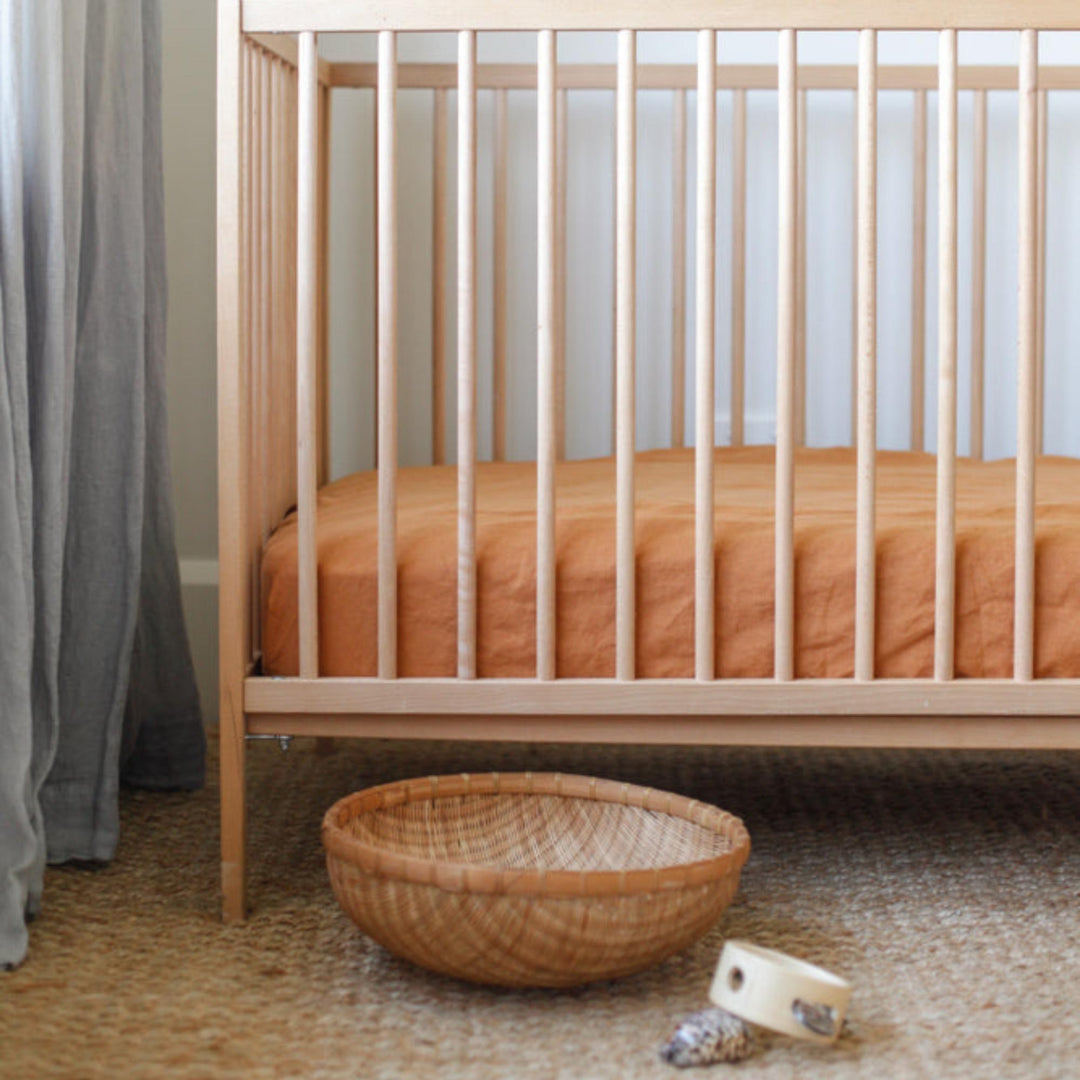 Foxtrot Home French Flax Linen styled in a baby's bedroom with Ochre Cot Sheet and Bassinet Sheets.