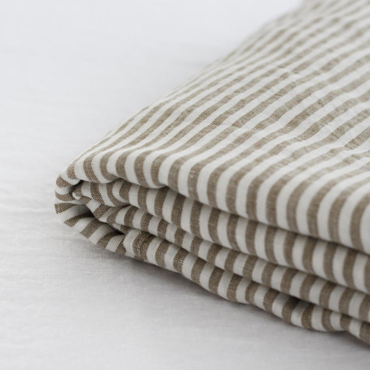 Foxtrot Home French Flax Linen styled in a bedroom with Olive Green Stripes Sheets Sets.