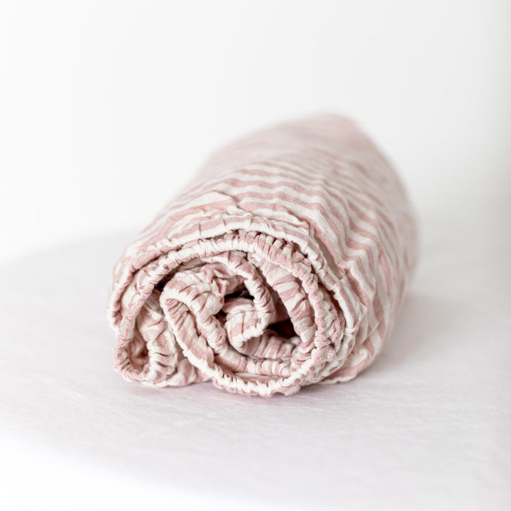 Foxtrot Home French Flax Linen styled in a baby's bedroom with Pink Stripes Cot Sheet and Bassinet Sheets.