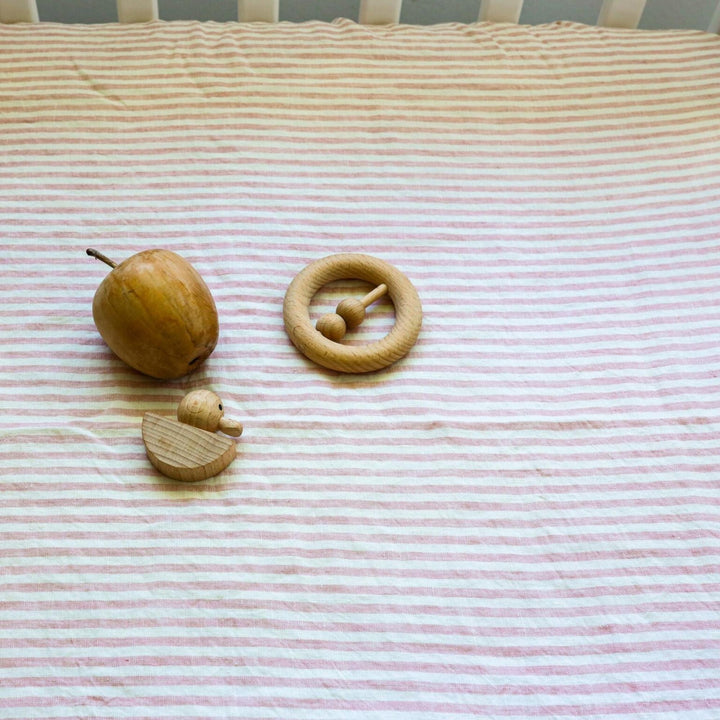 Foxtrot Home French Flax Linen styled in a baby's bedroom with Pink Stripes Cot Sheet and Bassinet Sheets.