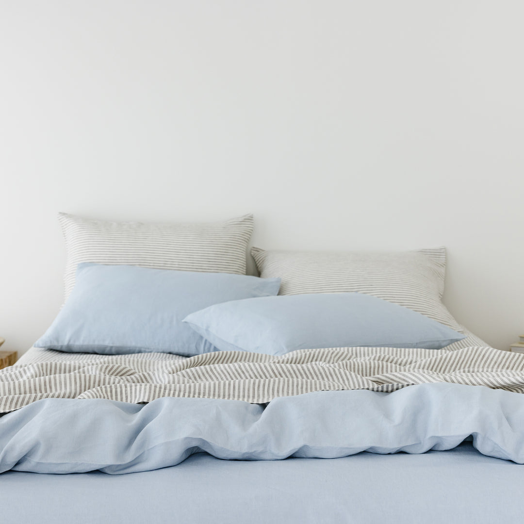 Foxtrot Home French Flax Linen styled in a bedroom with Powder Blue Duvet, Grey Stripes Sheets Sets and Pillowcases.