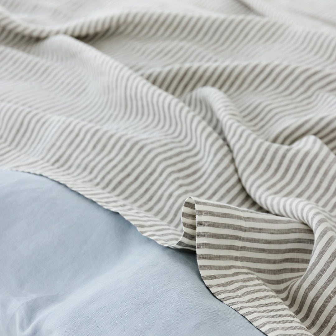 Foxtrot Home French Flax Linen styled in a bedroom with Powder Blue Duvet, Grey Stripes Sheets Sets and Pillowcases.