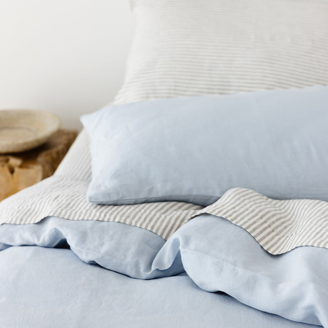 Foxtrot Home French Flax Linen styled in a bedroom with Powder Blue Duvet, Grey Stripes Sheets Sets and Pillowcases.