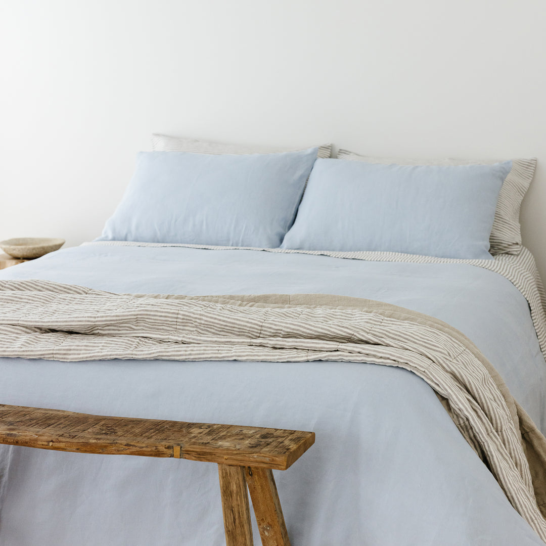 Foxtrot Home French Flax Linen styled in a bedroom with Powder Blue Duvet, Grey Stripes Sheets Sets and Pillowcases.