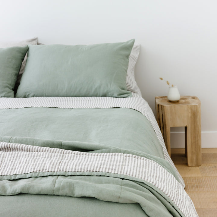 Foxtrot Home French Flax Linen styled in a bedroom with Sage Green Duvet, Grey Stripes Sheets and Pillowcases.