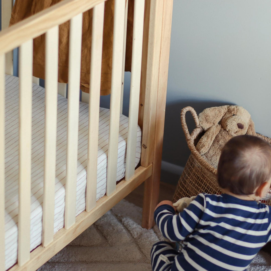 Foxtrot Home French Flax Linen styled in a baby's bedroom with Tobacco Stripes Cot Sheet and Bassinet Sheets.