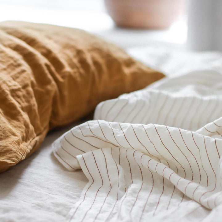 Foxtrot Home French Flax Linen styled in a bedroom with Tobacco Stripes Fitted Sheet.