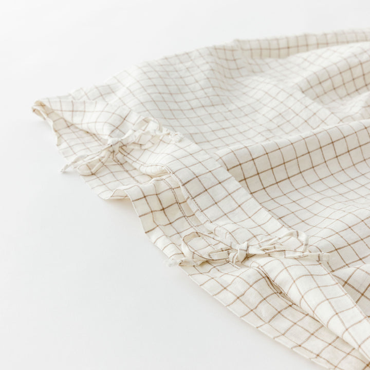 Foxtrot Home French Flax Linen styled in a baby's bedroom with a Malt Brown Grid Cot Duvet.