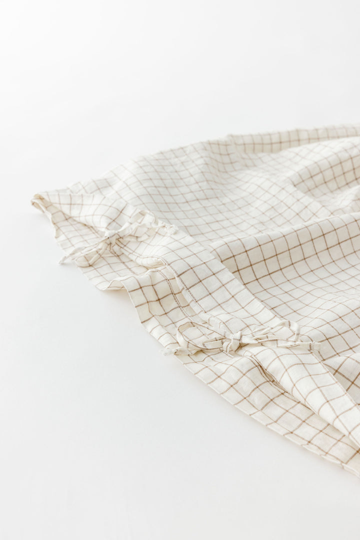 Foxtrot Home French Flax Linen styled in a baby's bedroom with a Malt Brown Grid Cot Duvet.