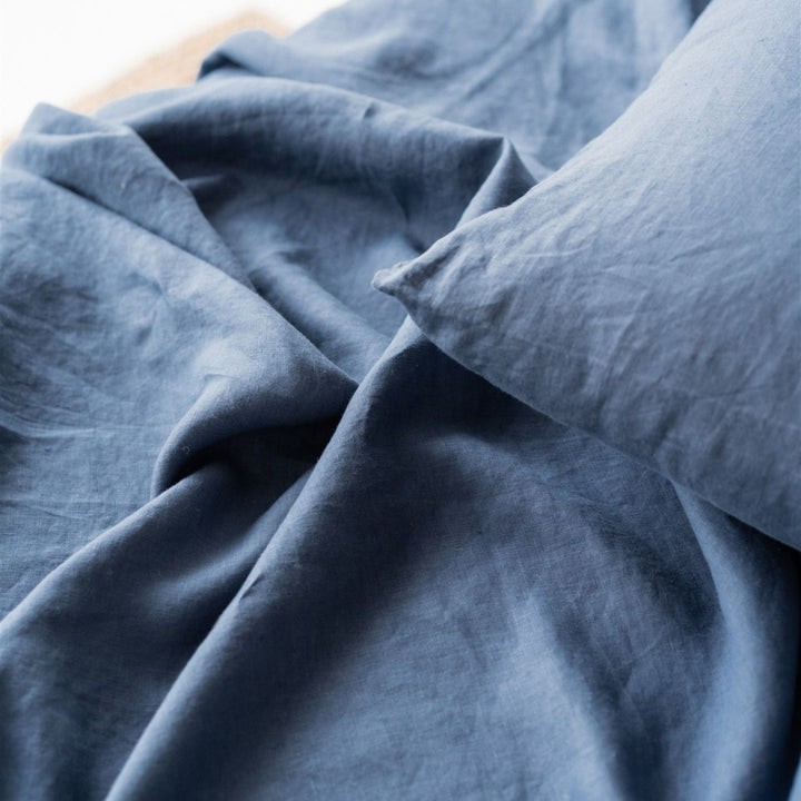 Foxtrot Home French Flax Linen styled in a bedroom with Coastal Blue Cushion Cover.