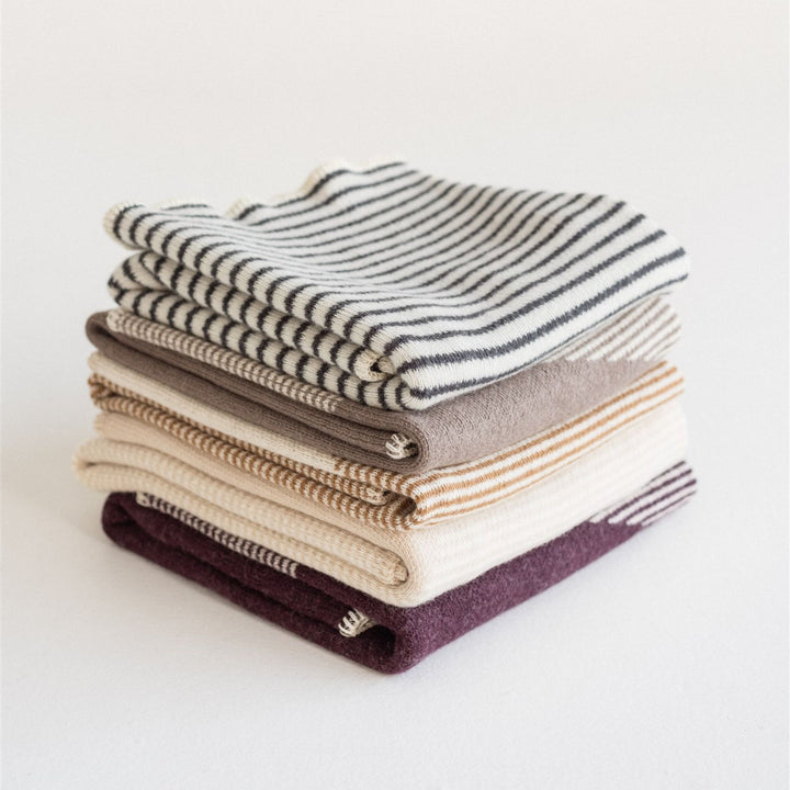 Foxtrot Home New Zealand Wool Throw Blankets in Geometric Pattern stacked in five colours, Fig Pampas Ginger Honey Mushroom and Charcoal Stripes