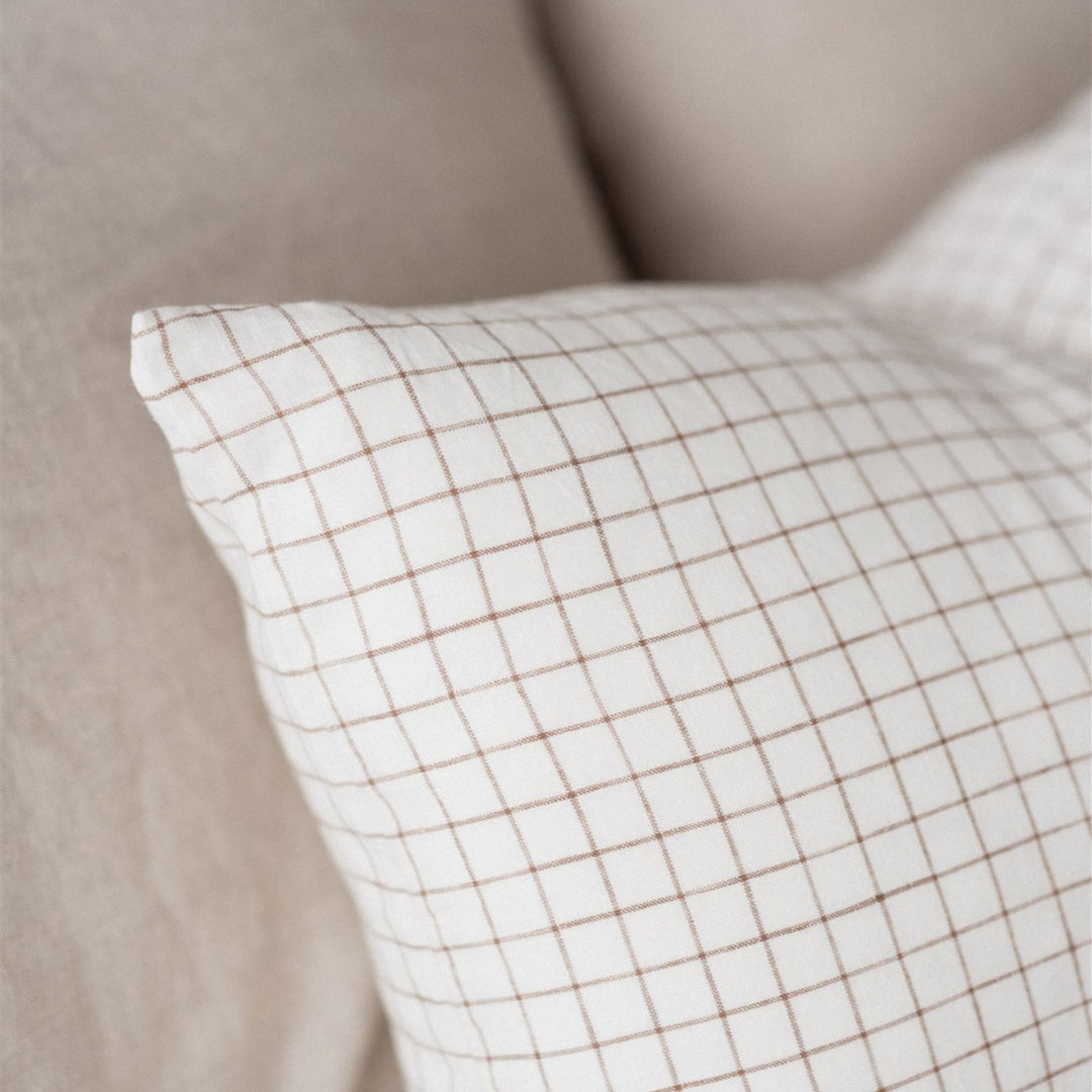 Foxtrot Home French Flax Linen styled in a bedroom with Malt Brown Grid Rectangle Cushion Cover.