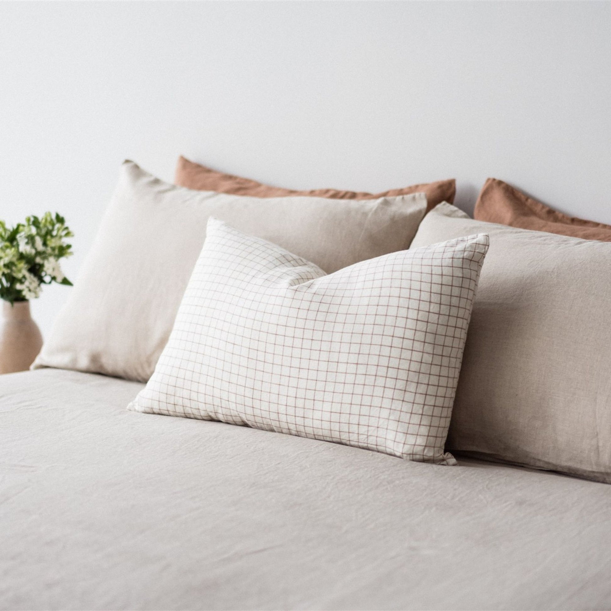 Foxtrot Home French Flax Linen styled in a bedroom with Malt Brown Grid Rectangle Cushion Cover.