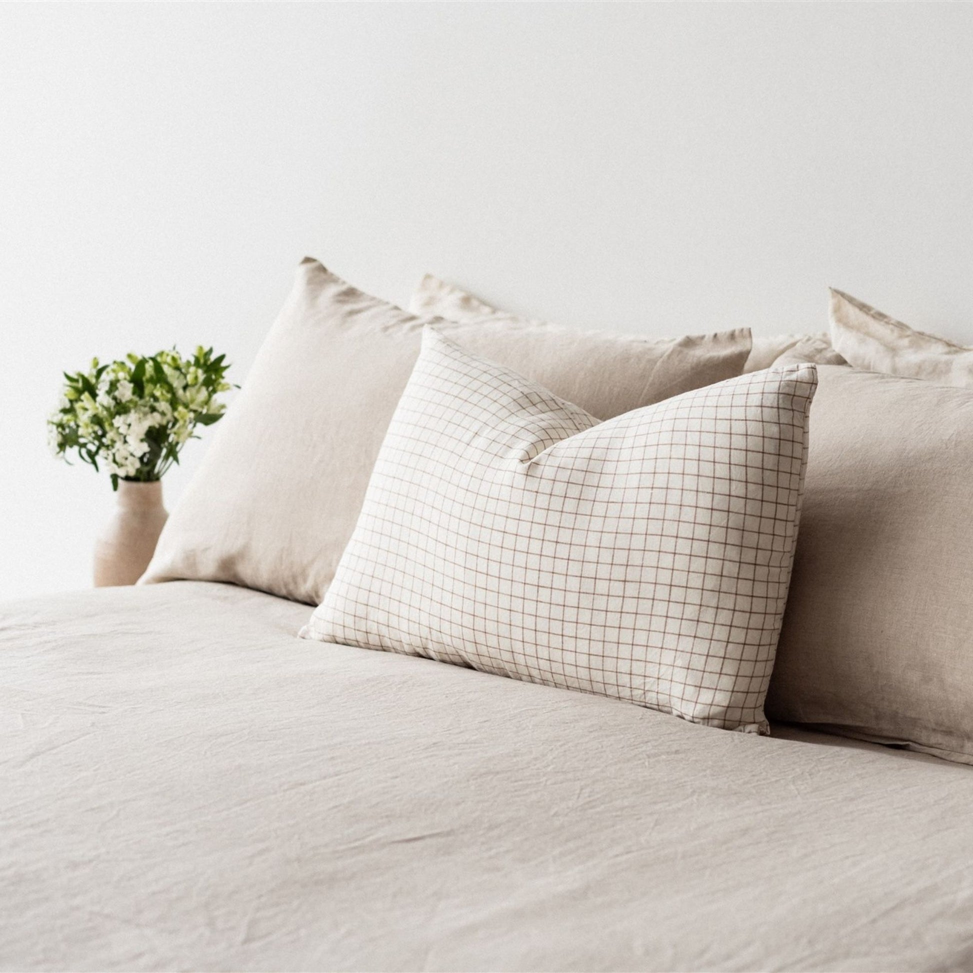 Foxtrot Home French Flax Linen styled in a bedroom with Malt Brown Grid Rectangle Cushion Cover.