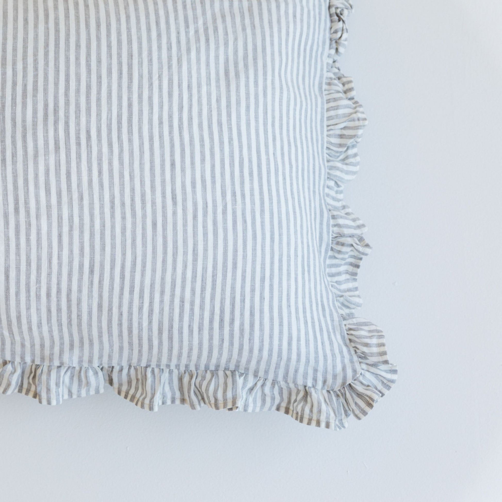 Foxtrot Home French Flax Linen styled in a bedroom with a Grey Stripes Ruffles Cushion Cover