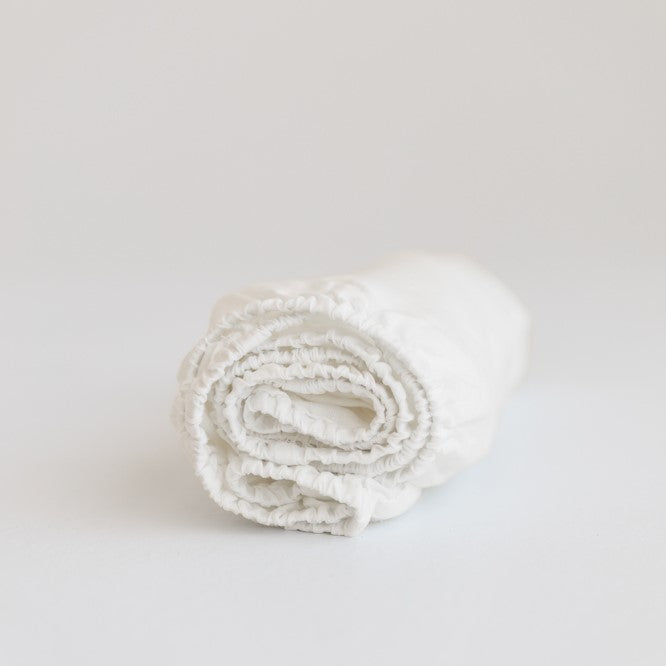 Foxtrot Home French Flax Linen styled in a baby's bedroom with Off White Cot Sheet and Bassinet Sheets.