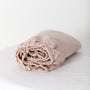 Foxtrot Home French Flax Linen styled in a baby's bedroom with Blush Pink Cot Sheet and Bassinet Sheets.