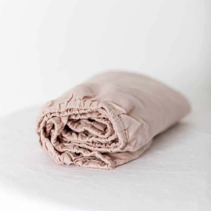 Foxtrot Home French Flax Linen styled in a baby's bedroom with Blush Pink Cot Sheet and Bassinet Sheets.
