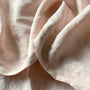Foxtrot Home French Flax Linen styled in a baby's bedroom with Blush Pink Cot Sheet and Bassinet Sheets.