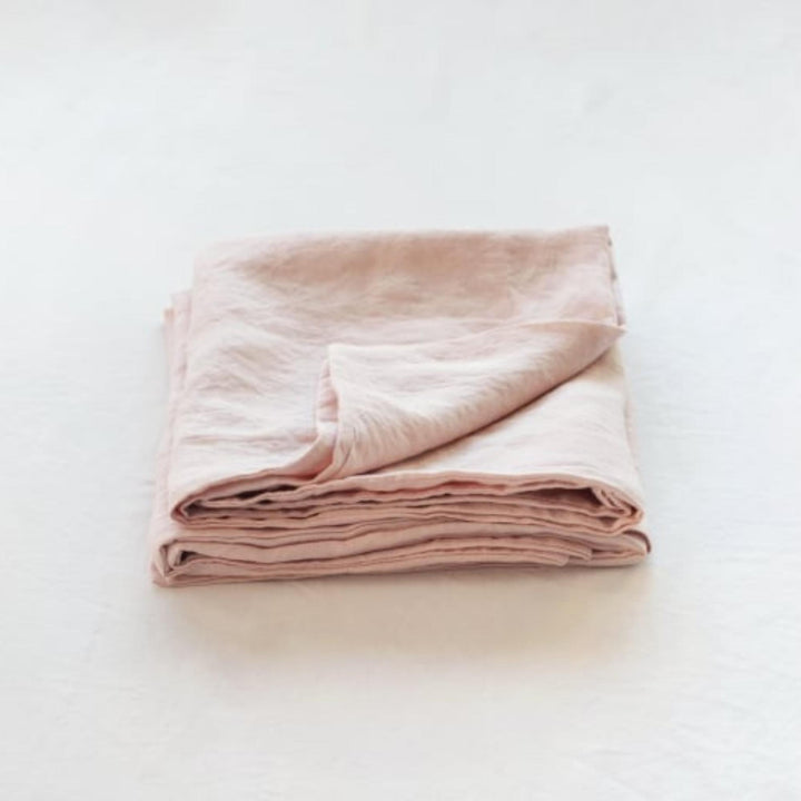Foxtrot Home French Flax Linen styled in a baby's bedroom with Blush Pink Cot Sheet and Bassinet Sheets.