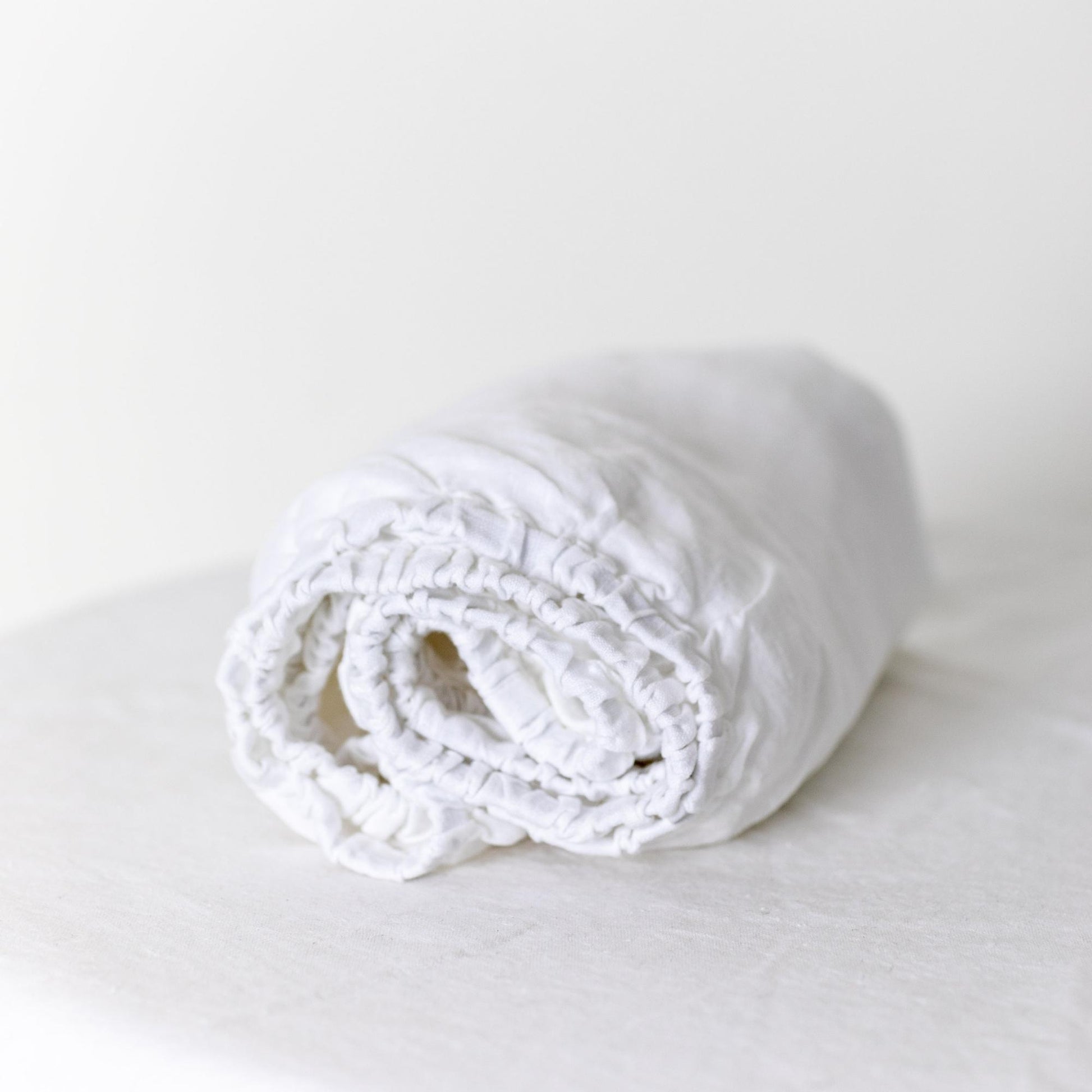 Foxtrot Home French Flax Linen styled in a baby's bedroom with Brilliant White Cot Sheet and Bassinet Sheets.