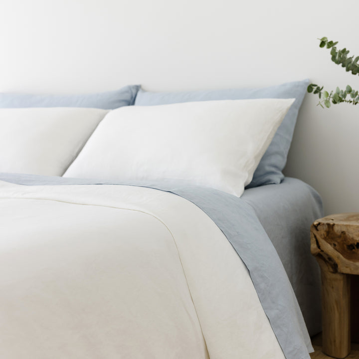 Foxtrot Home French Flax Linen styled in a bedroom with Brilliant White Duvet, Powder Blue Sheets Set and Pillowcases.