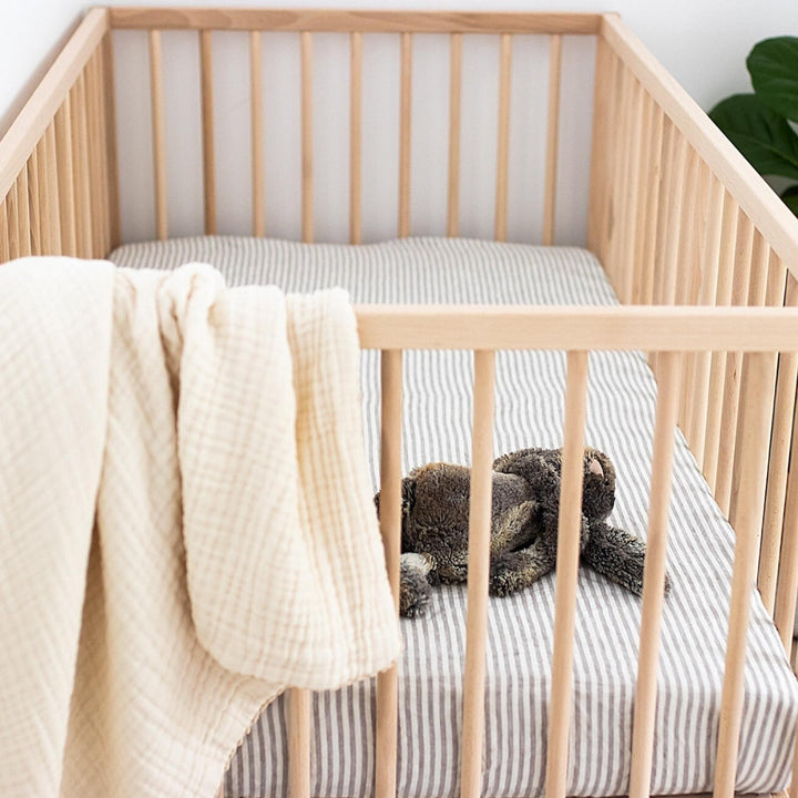 Foxtrot Home French Flax Linen styled in a baby's bedroom with Grey Stripes Cot Sheet and Bassinet Sheets.