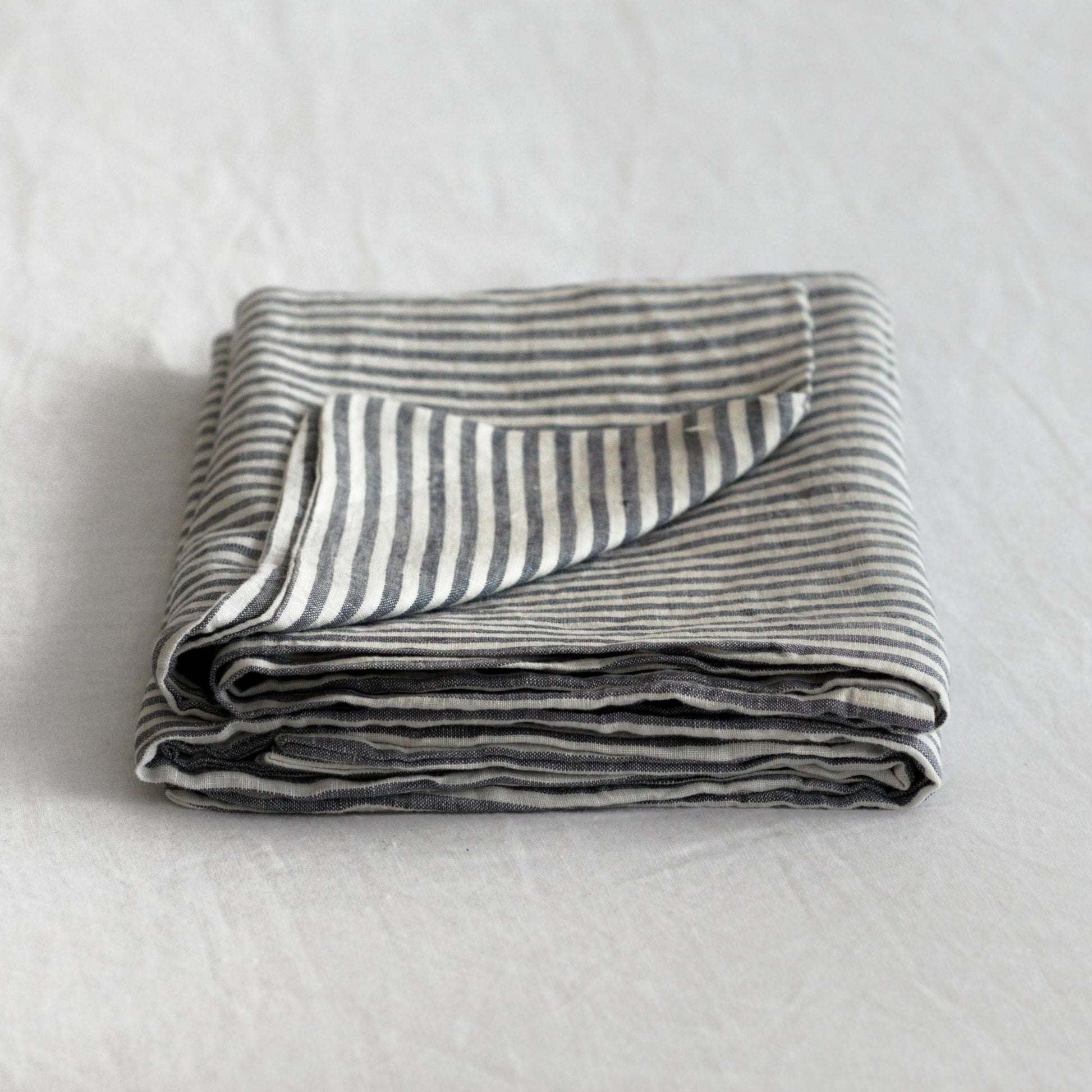 Foxtrot Home French Flax Linen styled in a bedroom with Navy Stripes Pillowcases.
