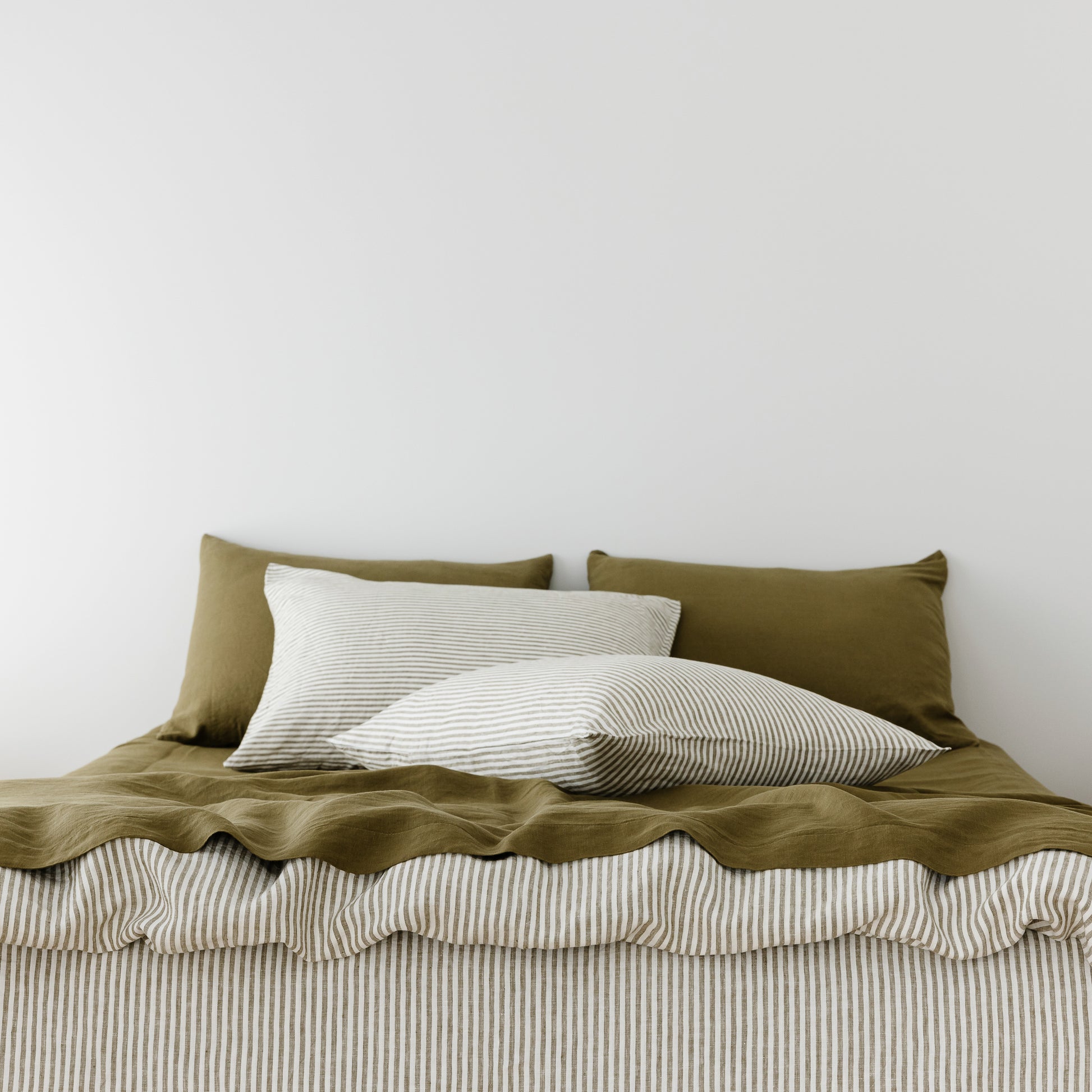 Foxtrot Home French Flax Linen styled in a bedroom with Olive Green Pillowcases.