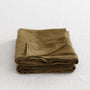 Foxtrot Home French Flax Linen styled in a bedroom with Olive Green Pillowcases.