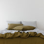 Foxtrot Home French Flax Linen styled in a bedroom with Olive Green Pillowcases.