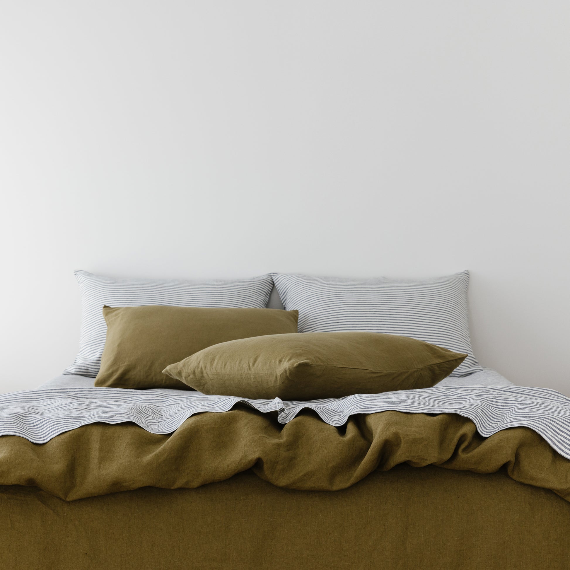 Foxtrot Home French Flax Linen styled in a bedroom with Olive Green Pillowcases.