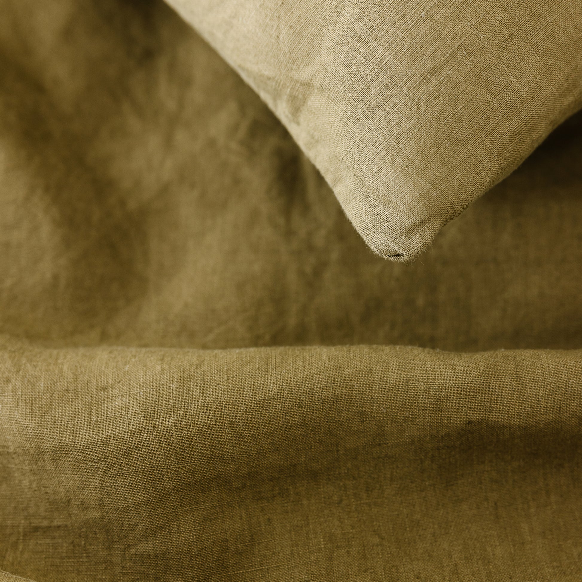 Foxtrot Home French Flax Linen styled in a bedroom with Olive Green Pillowcases.